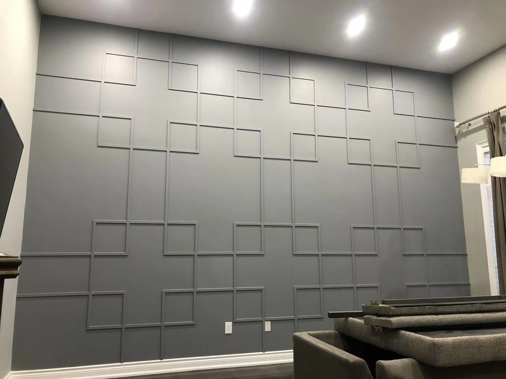 The finished two-storey feature wall, trim and wall painted the same grey.